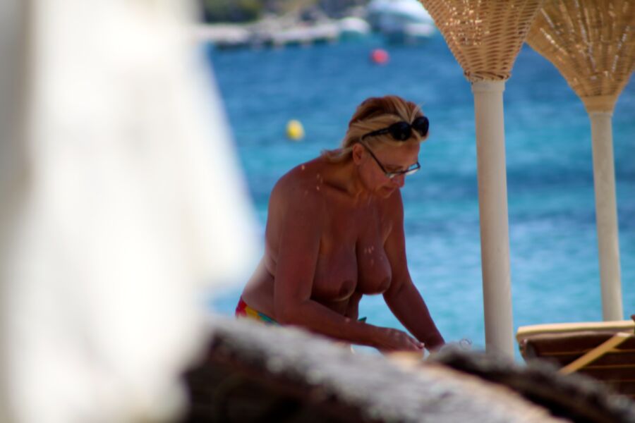 Free porn pics of Blonde mature caught topless in Ornos beach, Mykonos 1 of 8 pics